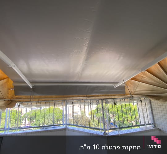 סוכך בד מתוח על מרפסת עם מסגרת מתכת